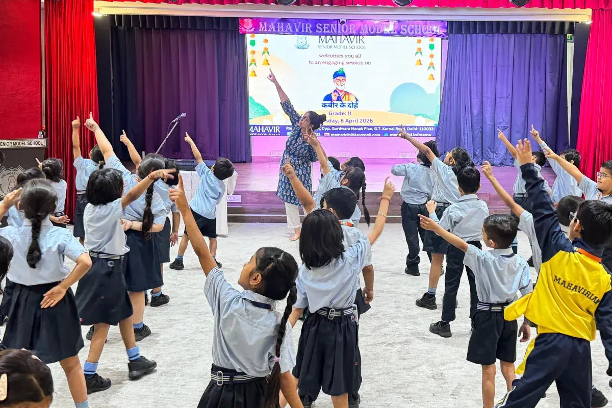 Children pointing skyward during interactive Kabir session at Mahavir Senior Model School, Delhi, April 2026