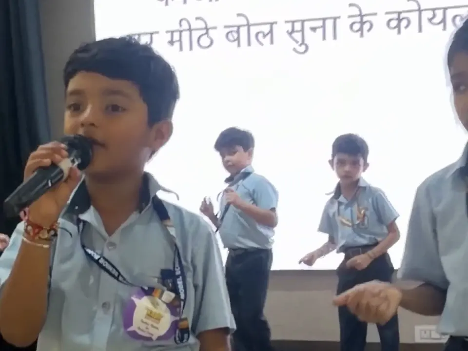 A child of Class 2 explaining a Kabir doha into the microphone on stage